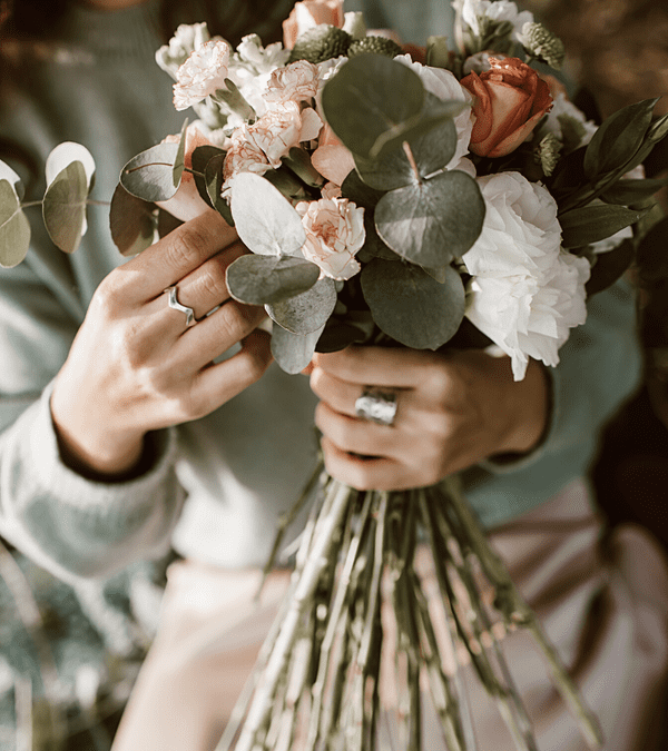 une personne tient un bouquet de fleurs